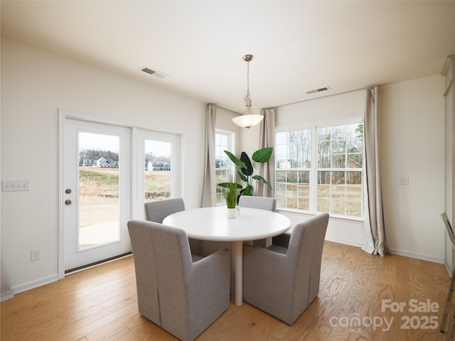 dining room with visible vents, light wood-style flooring, and baseboards