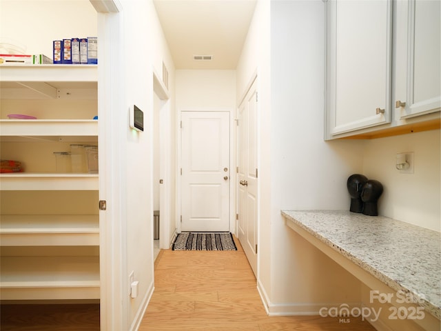 hallway with visible vents and light wood-style floors