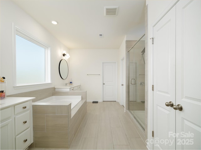 bathroom featuring a garden tub, recessed lighting, visible vents, a shower stall, and vanity