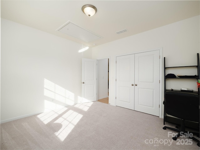 unfurnished office featuring carpet, visible vents, and attic access