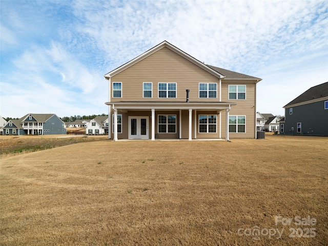 rear view of property with french doors and a lawn