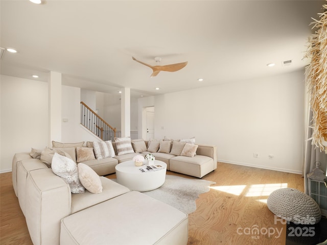 living area with recessed lighting, visible vents, stairway, and baseboards