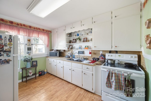 kitchen with white appliances, light wood-type flooring, white cabinetry, and sink