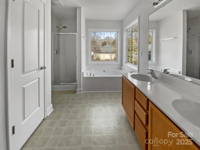 bathroom with a garden tub, double vanity, a sink, and a shower stall