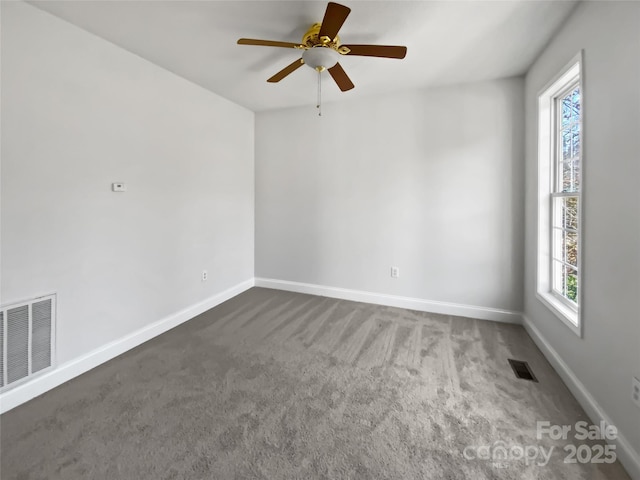 spare room featuring ceiling fan, baseboards, visible vents, and dark carpet