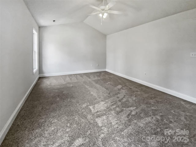 spare room with lofted ceiling, ceiling fan, baseboards, and dark colored carpet