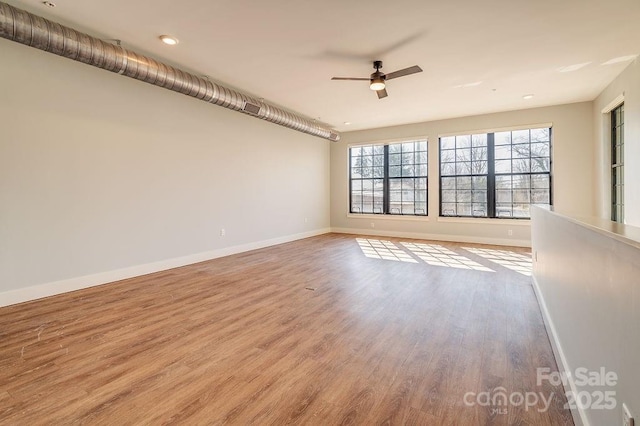 unfurnished room featuring ceiling fan, baseboards, and wood finished floors