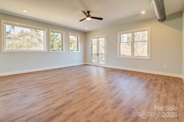 unfurnished room featuring french doors, light wood finished floors, a ceiling fan, and baseboards