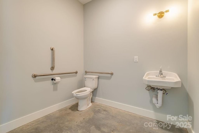 bathroom with baseboards, unfinished concrete flooring, and toilet