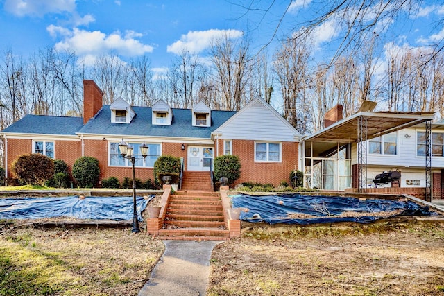 view of front of house featuring brick siding and a chimney