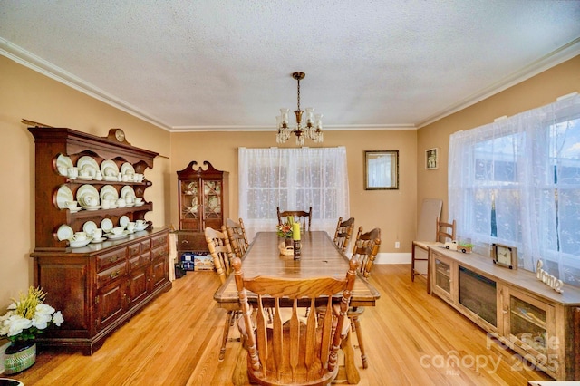 dining room featuring ornamental molding, light wood-style flooring, and a notable chandelier