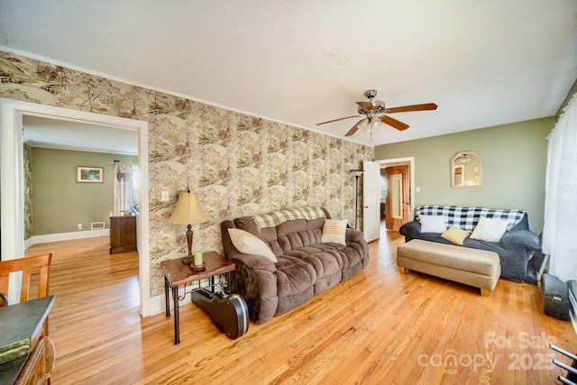 living room with visible vents, ceiling fan, wood finished floors, baseboards, and wallpapered walls