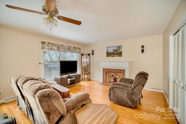 living area featuring light wood-type flooring, a brick fireplace, and baseboard heating