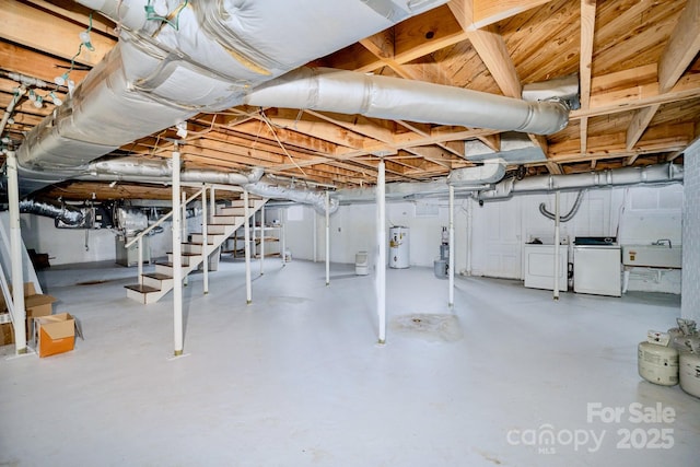 unfinished basement with stairs, water heater, a sink, and independent washer and dryer