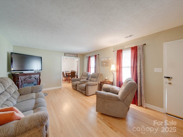 living room featuring a textured ceiling and light wood-type flooring