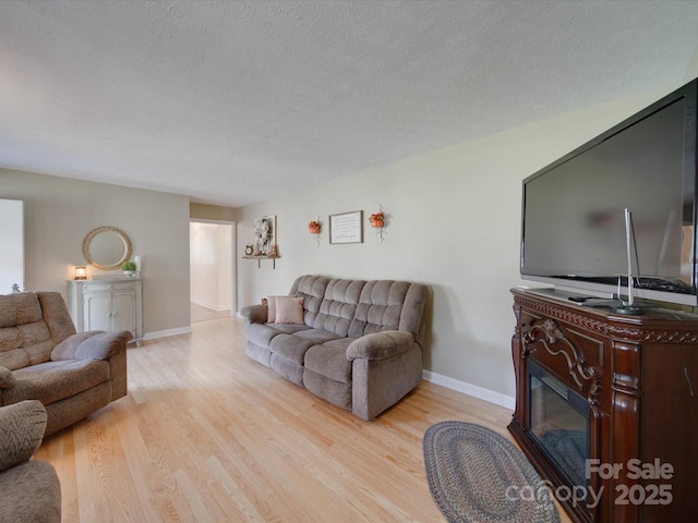 living room featuring a textured ceiling and light hardwood / wood-style floors