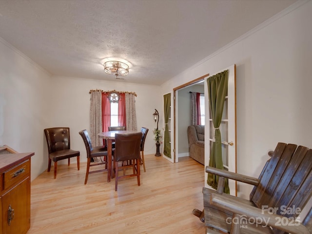 dining room featuring a textured ceiling, crown molding, and light hardwood / wood-style flooring