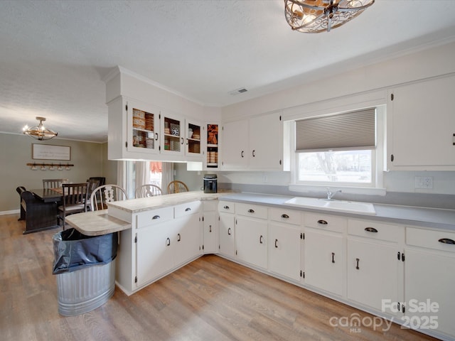 kitchen with sink, white cabinetry, and light hardwood / wood-style floors