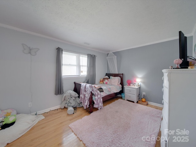 bedroom featuring ornamental molding, a textured ceiling, and hardwood / wood-style flooring