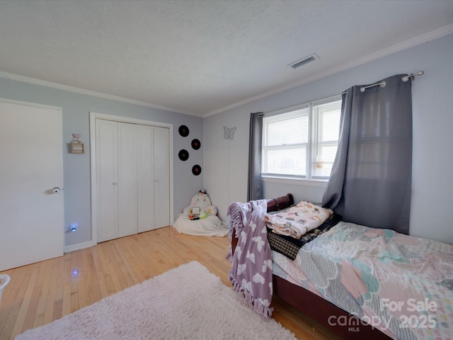 bedroom featuring crown molding and light wood-type flooring