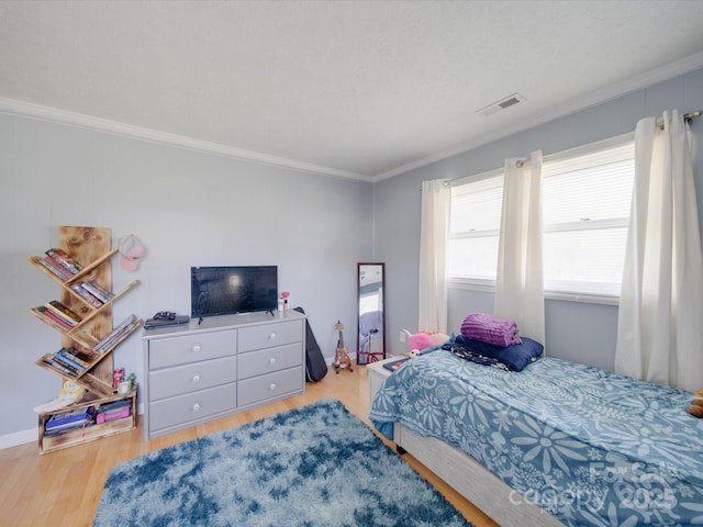 bedroom featuring light hardwood / wood-style flooring and ornamental molding