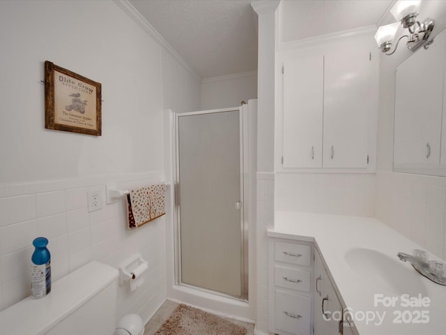 bathroom with tile walls, an enclosed shower, vanity, and ornamental molding