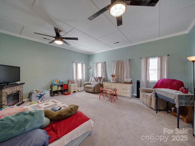 carpeted living room with a wealth of natural light, ceiling fan, and a fireplace