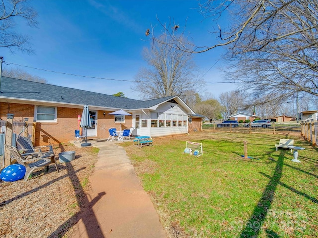 back of house with a patio area, a sunroom, and a yard