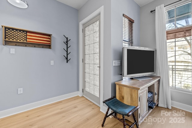 living area with light wood-style flooring and baseboards