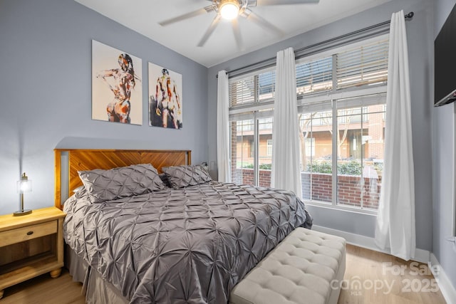 bedroom with wood finished floors, a ceiling fan, and baseboards