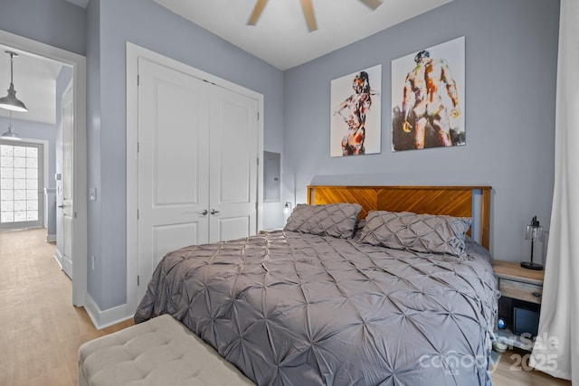 bedroom with baseboards, a ceiling fan, a closet, and wood finished floors