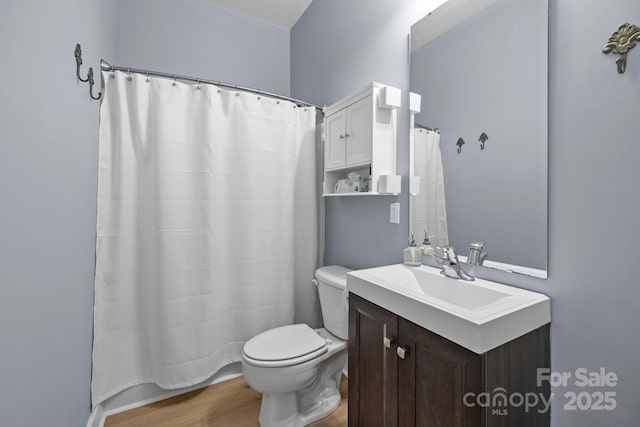 full bath with wood finished floors, a shower with shower curtain, vanity, and toilet