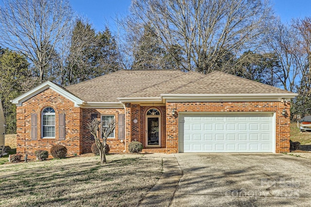 ranch-style home featuring an attached garage, brick siding, a shingled roof, concrete driveway, and a front lawn