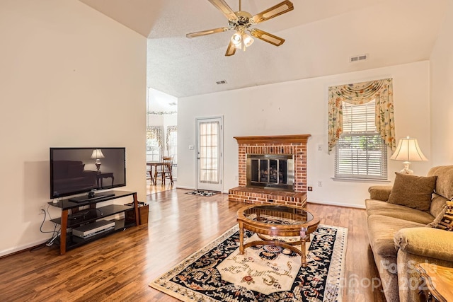 127 Lakewood Circle Dr, Mooresville, NC 28117 - living area with a fireplace, lofted ceiling, visible vents, a ceiling fan, and wood finished floors