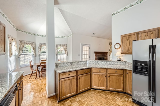 127 Lakewood Circle Dr, Mooresville, NC 28117 - kitchen featuring brown cabinetry, dishwasher, stainless steel fridge with ice dispenser, lofted ceiling, and a textured ceiling