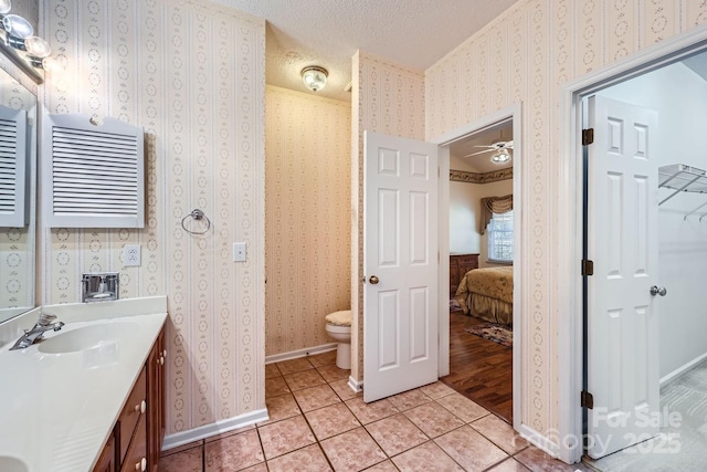 127 Lakewood Circle Dr, Mooresville, NC 28117 - ensuite bathroom with toilet, a sink, a textured ceiling, tile patterned flooring, and wallpapered walls