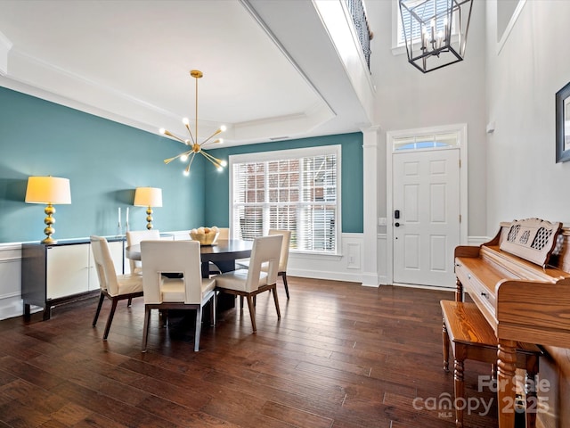 dining area featuring dark hardwood / wood-style floors, an inviting chandelier, and a raised ceiling