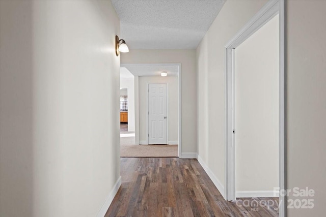 corridor featuring dark hardwood / wood-style floors and a textured ceiling