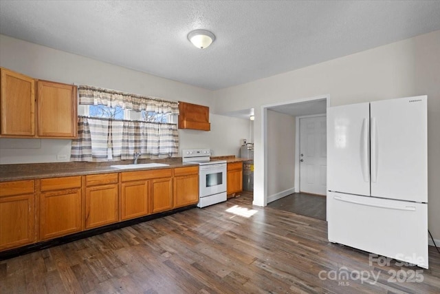 kitchen featuring sink, dark wood-type flooring, white appliances, and a textured ceiling