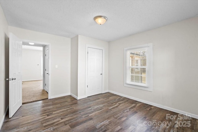 unfurnished bedroom with a closet, dark hardwood / wood-style flooring, and a textured ceiling