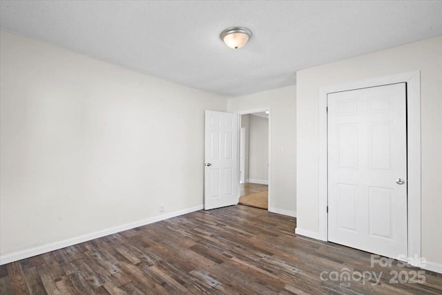 unfurnished bedroom with dark hardwood / wood-style flooring