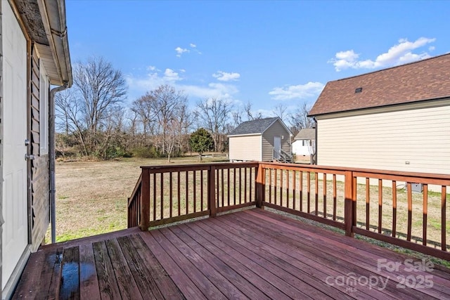 wooden terrace featuring a lawn and a storage shed