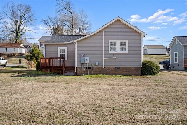 rear view of property with a lawn and a wooden deck