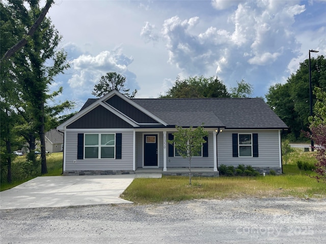 ranch-style house with a porch and roof with shingles