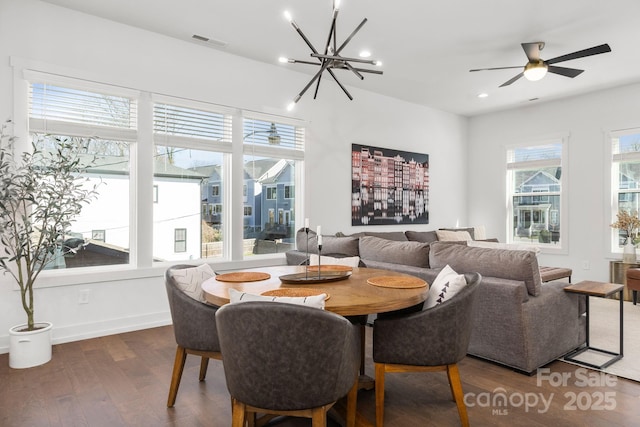 dining room featuring dark wood finished floors, recessed lighting, visible vents, baseboards, and ceiling fan with notable chandelier