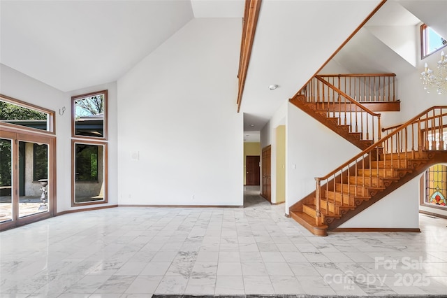 unfurnished living room with high vaulted ceiling