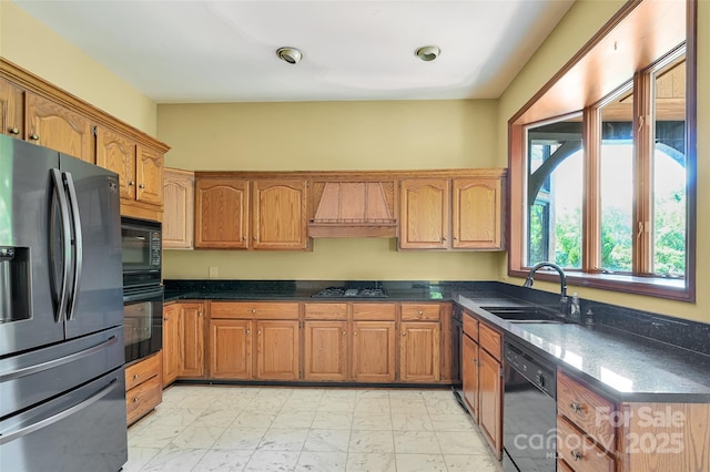 kitchen featuring dark stone countertops, sink, custom exhaust hood, and black appliances