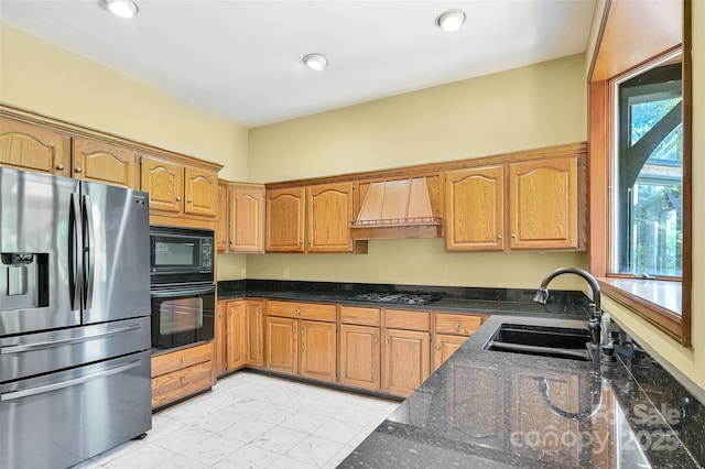 kitchen with dark stone countertops, sink, custom exhaust hood, and black appliances