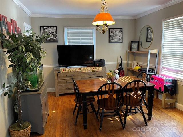 dining area featuring ornamental molding, baseboards, and hardwood / wood-style flooring