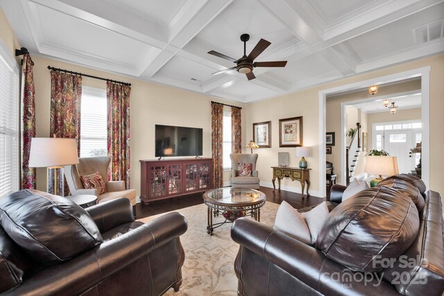 living area with beamed ceiling, coffered ceiling, and a wealth of natural light